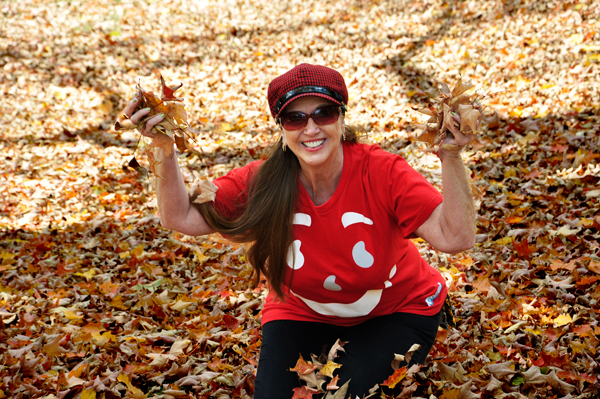 Karen Duquette playing in the fall leaves